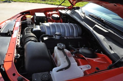 1973 Ford Ranchero - The engine bay of a red vehicle is visible, a HEMI intake manifold and air intake system.