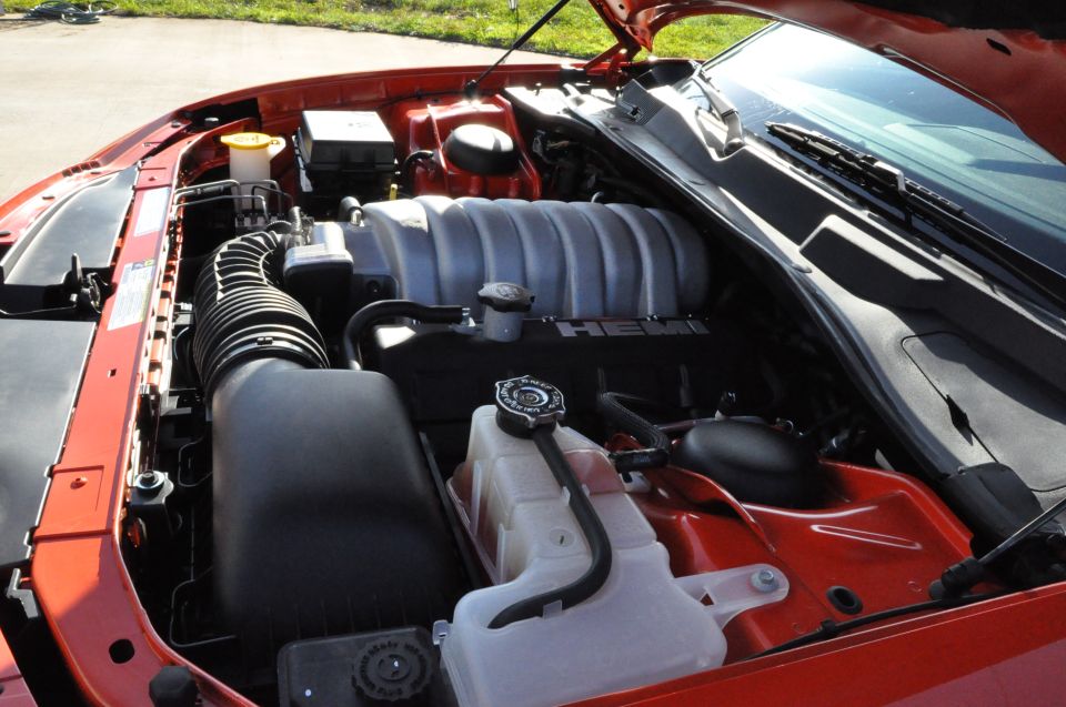 Red engine bay with a silver intake manifold labeled HEMI, air intake, and coolant reservoir
