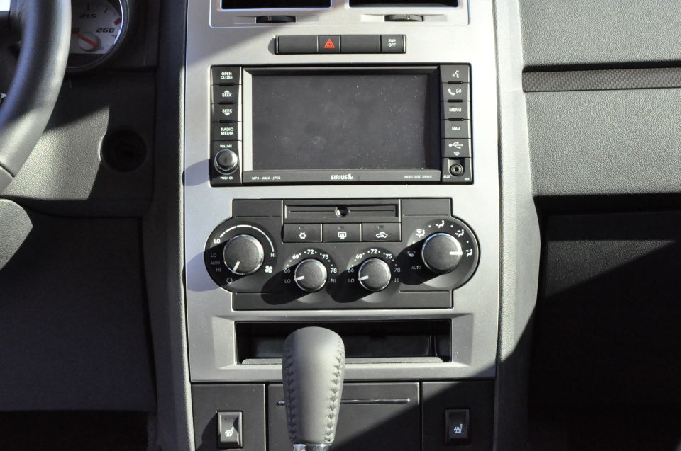 Car interior showing dashboard center console with infotainment screen, climate controls, and gear shifter