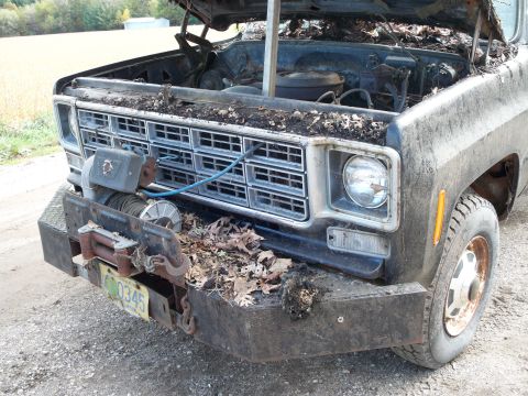 1988 Ford F-150 - This truck shows significant damage, with its hood open and debris scattered across the engine bay and front end.