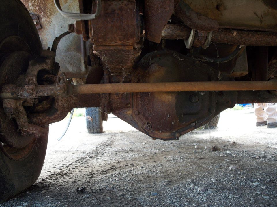 Undercarriage view of rusty truck differential and suspension components