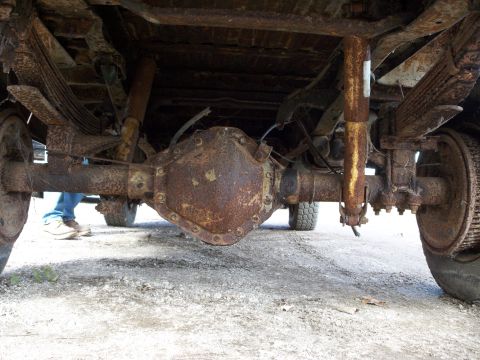 1988 Ford F-150 - The underside of a heavily rusted truck reveals its rear axle and suspension components.