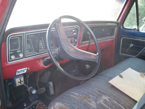 1988 Ford F-150 - The interior of a vintage truck shows a worn dashboard and torn seat, with a "Burbank Spring" sticker on the dash.