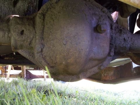 1988 Ford F-150 - The underside of a truck shows a heavily soiled rear axle differential assembly.