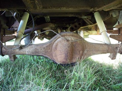 1988 Ford F-150 - Underside view of a heavily rusted rear axle and suspension system of an older truck.