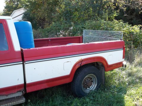 1988 Ford F-150 - This pickup truck has a two-tone red and white paint scheme with a white stripe. A blue barrel is in the bed.