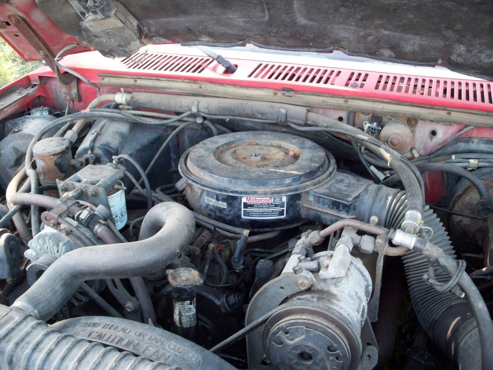 Engine bay of a 1988 Ford F-150, showing the air cleaner, hoses, and engine components