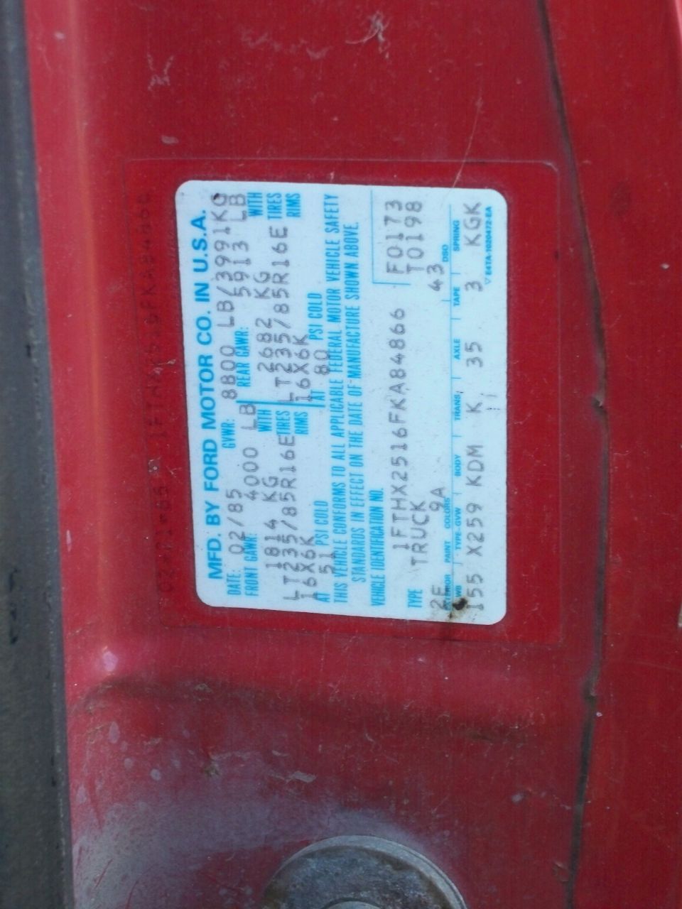 Ford truck certification label, 02/85 build date, VIN 1FTHX2516FKA84866, on a red door jamb