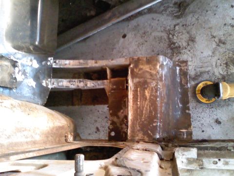 1969 Ford Mustang - This image shows a section of a vehicle's frame undergoing repair work, with evidence of rust and welding.