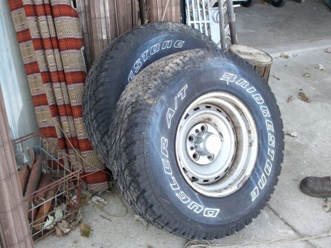 1988 Ford F-150 - Stack of four Bridgestone Dueler A/T tires, one mounted on a silver steel wheel.