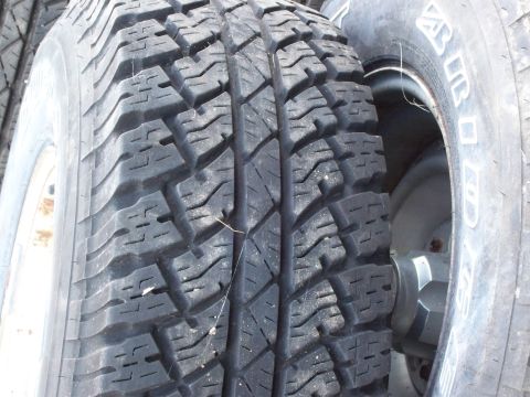 1988 Ford F-150 - A close-up view of a tire's tread pattern, with visible text on the sidewall of an adjacent tire.