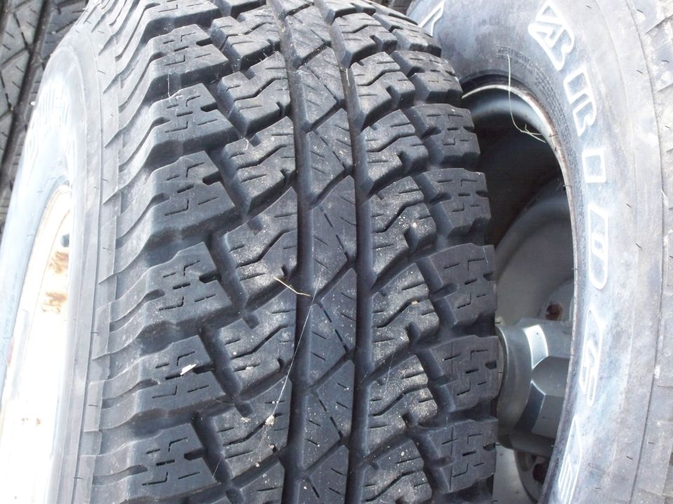 Tire tread close-up, showing deep grooves and a sidewall with some text