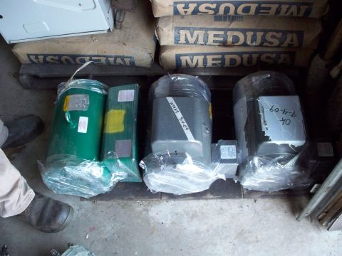 1988 Ford F-150 - Three industrial electric motors are stored on a pallet, with bags of cement stacked behind them.