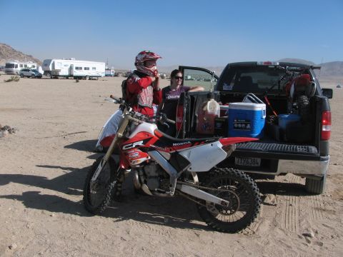 1996 Ford C-350 (Centurion Conversions) - A dirt bike is loaded into the bed of a pickup truck, ready for a day of racing.