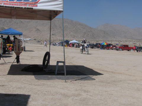 1996 Ford C-350 (Centurion Conversions) - A dirt bike race event is underway with spectators and vehicles gathered under tents.