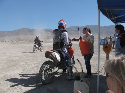 1996 Ford C-350 (Centurion Conversions) - A dirt bike rider is being refueled during a desert race event.