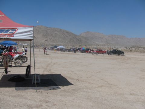1996 Ford C-350 (Centurion Conversions) - Outdoor event with dirt bikes and trucks in a desert setting under a clear blue sky.