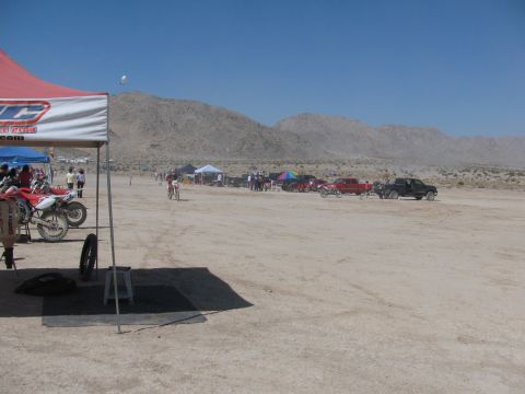 1996 Ford C-350 (Centurion Conversions) - A desert landscape hosts a dirt bike race event with tents and various vehicles parked in the background.