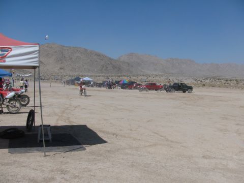 1996 Ford C-350 (Centurion Conversions) - Dirt bike race event with multiple vehicles and spectators in a desert environment.