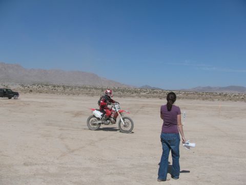 1996 Ford C-350 (Centurion Conversions) - A dirt bike rider races across a dry, dusty landscape under a clear blue sky.