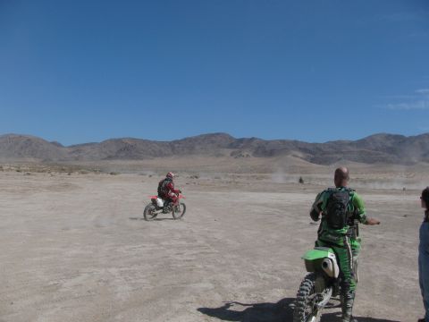 1996 Ford C-350 (Centurion Conversions) - Dirt bike riders are out in a dry, dusty desert with mountains in the distance under a clear blue sky.