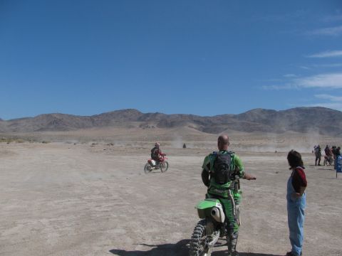 1996 Ford C-350 (Centurion Conversions) - Motorcyclists race across a dry, dusty terrain with mountains in the distance.