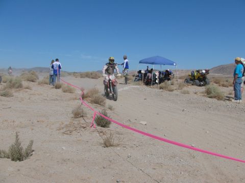 1996 Ford C-350 (Centurion Conversions) - A dirt bike race is underway in a desert environment, with participants and support vehicles visible.