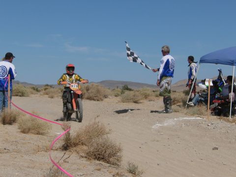 1996 Ford C-350 (Centurion Conversions) - A dirt bike race concludes with a checkered flag in a desert landscape.