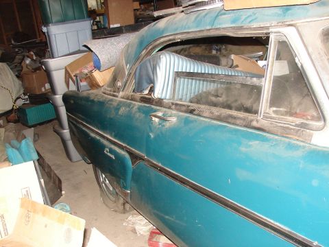 1973 Ford Ranchero - Side view of a dusty teal coupe with a blue interior, stored amongst various items in a garage.