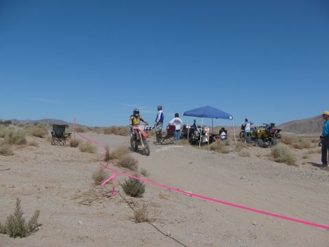 1996 Ford C-350 (Centurion Conversions) - A desert scene with a dirt bike race in progress, riders, ATVs, and spectators under a canopy.