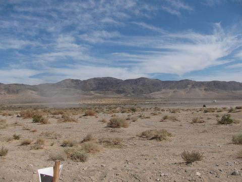 1996 Ford C-350 (Centurion Conversions) - A wide desert scene under a cloudy sky shows distant vehicles on a dirt track.
