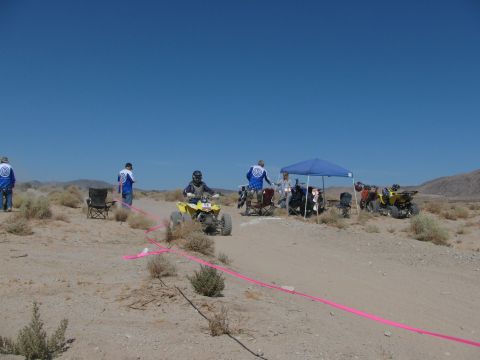 1996 Ford C-350 (Centurion Conversions) - Quad bikes and participants gathered in a desert landscape under a clear blue sky.