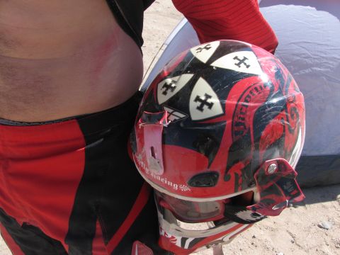 1996 Ford C-350 (Centurion Conversions) - A rider holds a dirt bike helmet, showing off its custom graphics and wear from use.