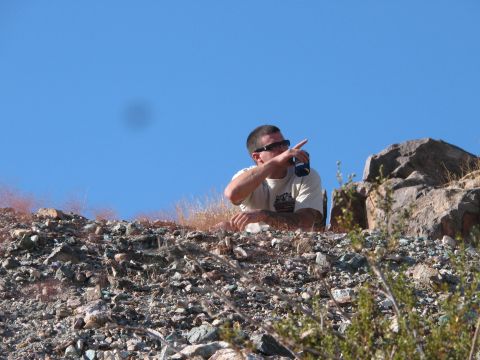1996 Ford C-350 (Centurion Conversions) - A man surveys the terrain, pointing towards something in the distance while holding a beverage can.