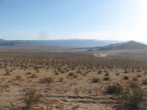 1996 Ford C-350 (Centurion Conversions) - Desert scene with dust clouds in the distance, likely from off-road vehicles.