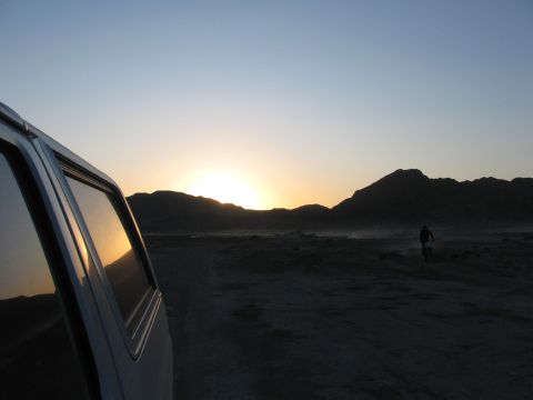 1996 Ford C-350 (Centurion Conversions) - Sunset over a desert scene with a dirt biker in the distance, viewed from the side of a van.
