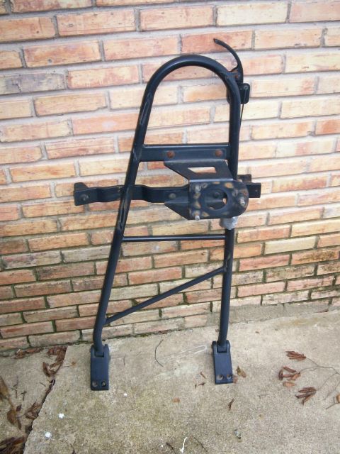 1993 Ford Bronco - This is a spare tire carrier, likely for an SUV, shown mounted against a brick wall.