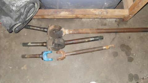 1997 Ford Ranger - Various driveshafts are laid out on a concrete surface, with a blue yoke visible on one.