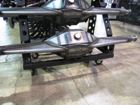 1986 Ford Bronco - Custom rear axles are displayed at an expo. The registry claims this is a 1986 Ford Bronco, but the image shows only parts.