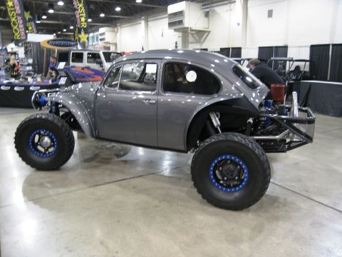1986 Ford Bronco - A custom Volkswagen Beetle is displayed indoors with large off-road tires and a modified rear end.