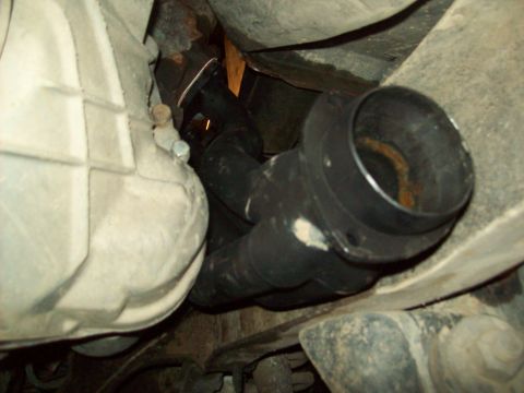 1985 Ford Bronco - Underside view of a vehicle's exhaust system and transmission housing.