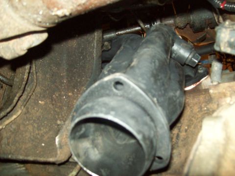1985 Ford Bronco - This image shows a close-up view of a vehicle's exhaust pipe connection, likely during maintenance or repair.