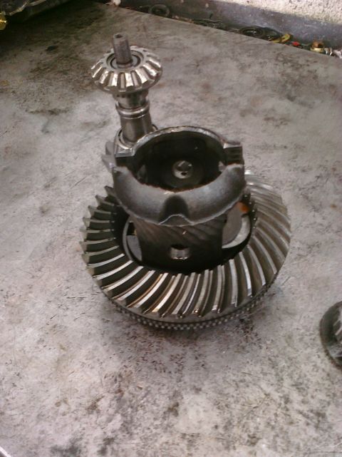 1993 Ford Bronco - A differential gear set, likely from a vehicle's drivetrain, is shown on a workshop surface. The Supermotors.net logo is visible in the low…
