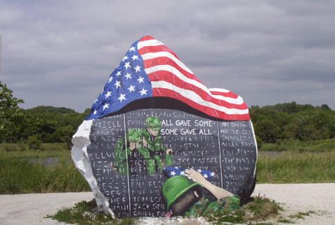 1981 Ford Bronco - A memorial stone depicts an American flag and soldiers, with names inscribed on its surface.