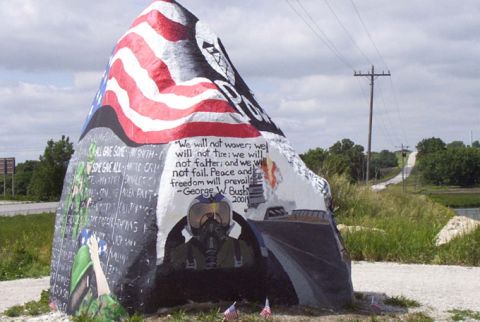 1981 Ford Bronco - A large rock painted with patriotic imagery, including an American flag and quotes from George W. Bush.