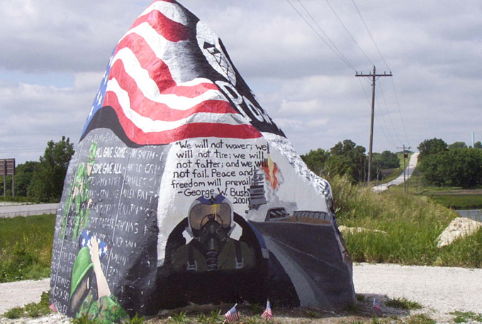 Painted rock with American flag, pilot's helmet, and quotes from George W. Bush