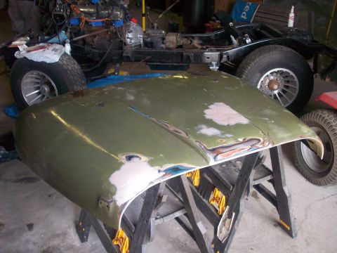 1978 Jeep CJ5 - Jeep CJ5 hood undergoing bodywork, with the vehicle chassis in the background.