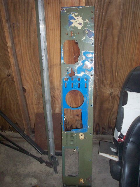 1978 Jeep CJ5 - A green dashboard panel, likely from an older vehicle, shows signs of wear and modification with various cutouts and painted areas.