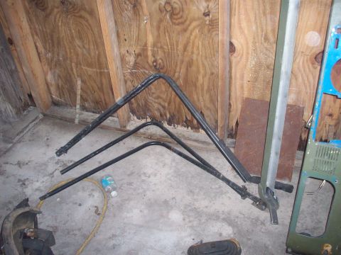 1978 Jeep CJ5 - Parts of a roll bar frame are stored indoors on a concrete floor.