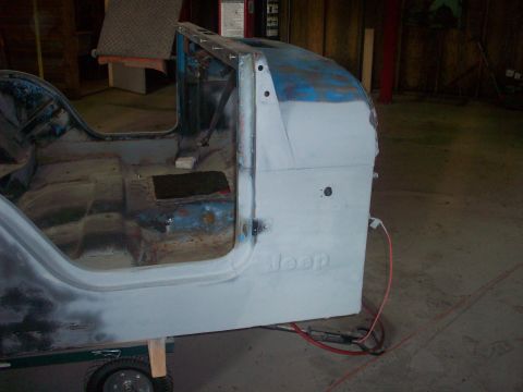 1978 Jeep CJ5 - The side panel of a Jeep CJ-series body, shown in primer, features the embossed 'Jeep' logo.